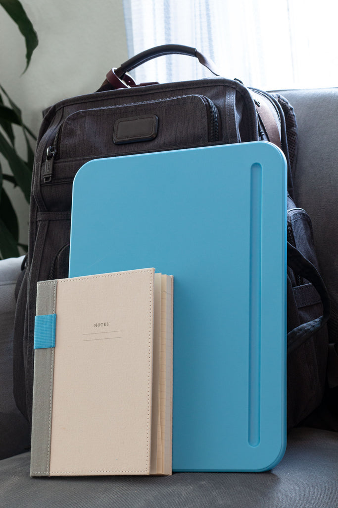 Compact Lap desk is shown next to a backpack and notebook.