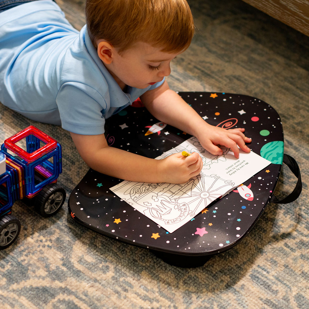 Kid coloring on the floor using the MyStyle Lap Desk