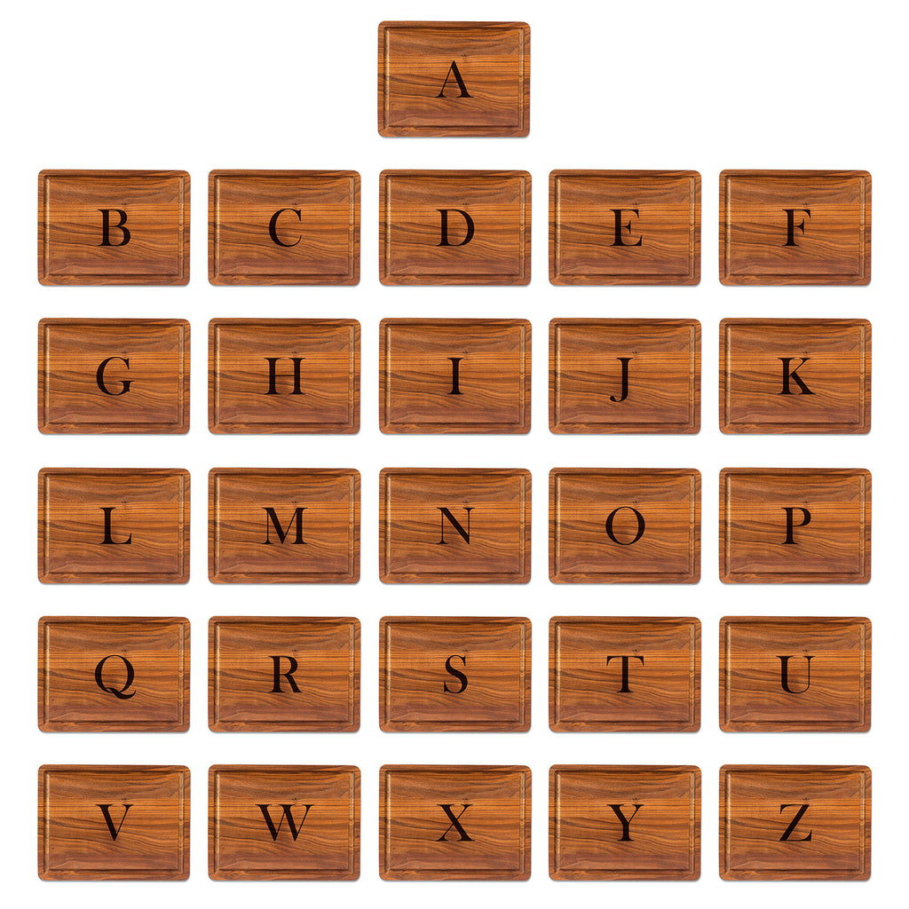 Set of 26 walnut cutting board letter engravings in the center using baskerville font, from A to z on a white background